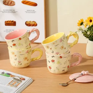 Charming ceramic coffee mug featuring floral patterns, colorful twisted handle, lid, and spoon.