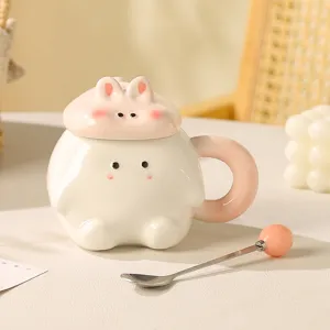 Close-up details of the cute ceramic rabbit mug with lid and matching spoon on cozy table.