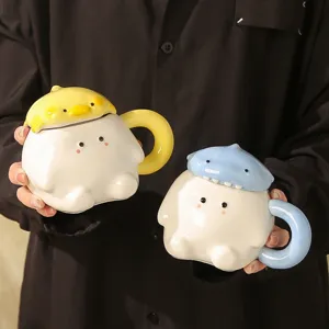 Close-up detail of cute ceramic couple mugs with lids, featuring adorable cartoon animal designs.