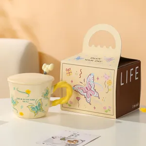 Dettaglio della tazza in ceramica con farfalla, coperchio, cucchiaio e confezione regalo.