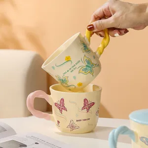 Tazza da caffè in ceramica elegante con grazioso motivo a farfalla e manico intrecciato.