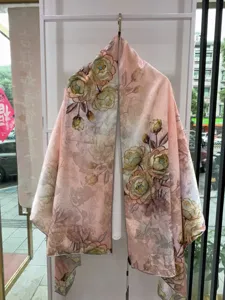 Detail shot of Chinese style floral print silk scarf hanging, featuring vintage pink tones.