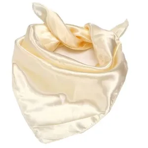 Detailed close-up of a smooth champagne satin square scarf showing its soft texture.