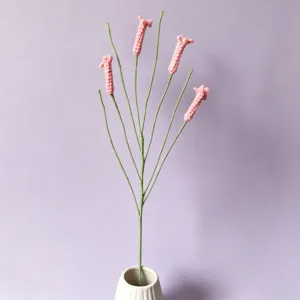 Handmade crochet firecracker flower branch detail, pink yarn floral decor for home interior.