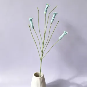 Handmade crochet firecracker flower detail, wool knit floral stem in a white ceramic vase.