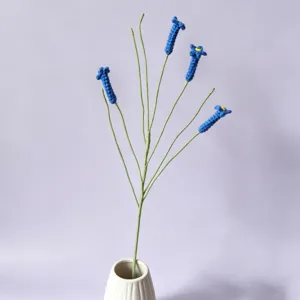 Handmade crochet blue flower bouquet in white ceramic vase, perfect for home decor detail.