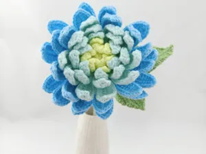 Gros plan sur fleur de dahlia au crochet dégradé faite à la main en vase, bel art de fil.