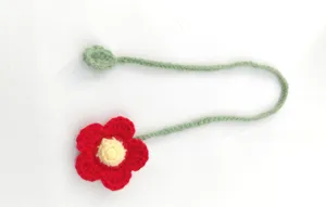 Handmade crochet flower bookmark detail shot, sweet red petal and green stem yarn craft