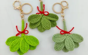 Handmade crochet green leaf keychain detail, cute pomelo leaf charm with sweet red bow.