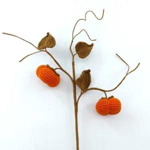 Handmade crochet persimmon branch detail, intricate orange fruit and brown leaf craftsmanship.