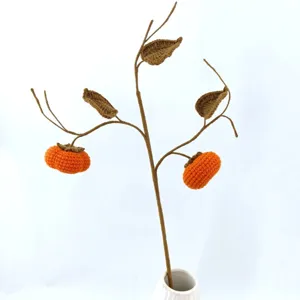 Handmade crochet persimmon branch decor detail, cute knitted fruit ornament for home.