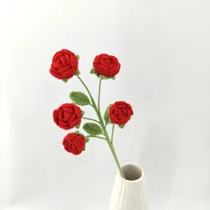 Detail view of handmade crochet red rose bouquet in a white vase, craft flower gift