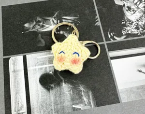 Llavero de estrella amarilla de ganchillo hecho a mano con bonita cara para bolsos.