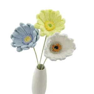 Handmade crocheted gerbera daisy bouquet, wool yarn flowers in white ceramic vase decor.