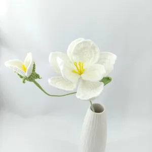 Close-up detail of hand-crocheted white bellflower in a ceramic vase for home decor.