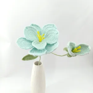 Handmade crochet blue flower detail, delicate knitted floral decor piece in white vase.