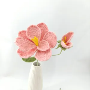 Detailed shot of handmade crochet pink flower bouquet with ceramic vase, perfect for home decor.