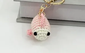 Primo piano dettagliato di un portachiavi a pesce uncinetto rosa fatto a mano con anello.