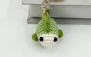 Vista dettagliata del portachiavi ciondolo borsa a crochet verde fatto a mano con gancio.