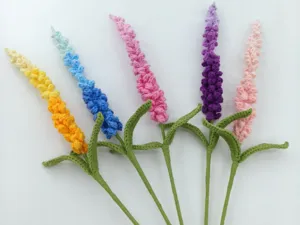 Detailaufnahme handgehäkelter Lavendelblüten aus bunter Wolle für kreative schöne Gestecke.