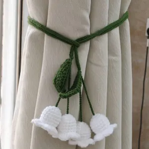 Handcrafted crochet curtain tieback featuring elegant lily of the valley design for home decor.