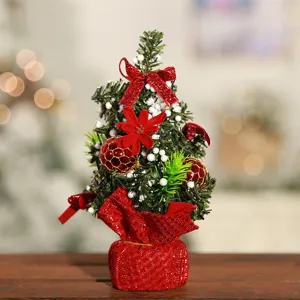 Mini sapin de noël décoration de table avec des nœuds rouges et boules pour les fêtes.