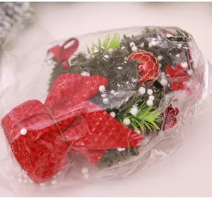 Vue de detail de mini sapin de Noel avec noeud rouge et baies de neige pour deco de table.