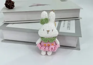 Detailaufnahme des handgefertigten Häkelhasen-Schlüsselanhängers mit rosa Kleidchen.