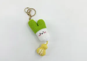 Detailed view of handmade crochet vegetable keychain with cute face and mini money bag.