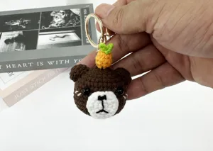 Handcrafted crochet brown bear keychain detail with cute carrot decor and gold ring.