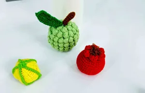 Handgemachte Häkelobst-Details zeigen niedliche Wolle gewebte Apfel und Granatapfel.
