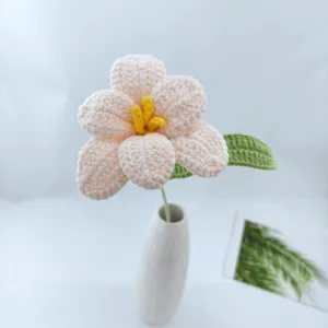 Handmade crochet yarn pink flower detail close up, knitted floral room decor item.