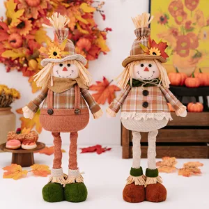 Detailed view of Thanksgiving harvest scarecrow plush dolls with sunflower and maple leaf decor.