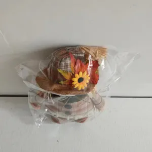 Thanksgiving harvest scarecrow doll detail showing sunflower and plaid hat decoration.