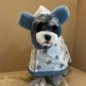 Dettaglio della mantella invernale per animali con orecchie di peluche e stampa mucca.