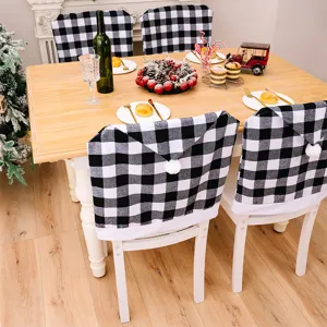 Zwart-witte ruit kerststoelhoezen met witte pompons voor feestelijke tafeldecoratie.