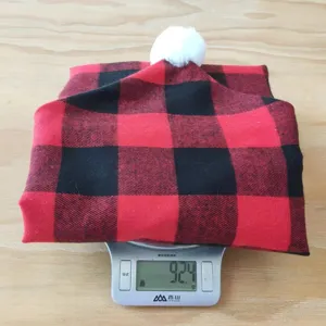 Rood-zwarte ruitjes Kerst stoelovertrek met een pluizige witte pompon decoratie.