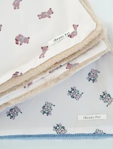 Close-up detail of thick plush pet blanket, soft flannel texture with cute animal prints.