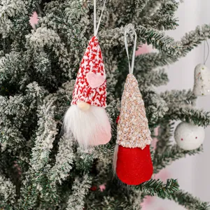 Dettaglio ornamento pendente di gnomo natalizio, bambola di peluche senza volto con berretto.