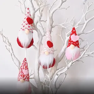 Simpatici gnomi senza volto appesi con cappelli a cuore per decorazioni natalizie e festa.