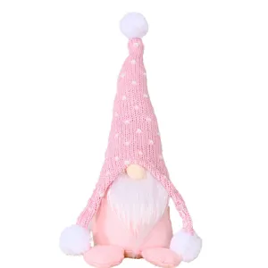 Cute pink Christmas gnome plush toy with knitted hat and white beard for holiday decoration.