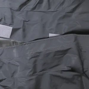 Detail de tissu pour imperméable de compagnie avec matériau gris résistant et sangle velcro.