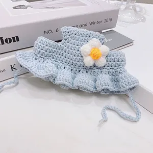 Handmade crochet pet hat detail, cute blue kitten bonnet with white flower and lace trim.