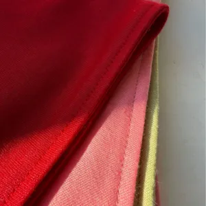 Plain pet bandana fabric close-up featuring neat stitching in red, pink, and green colors.