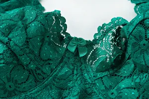 Dark green lace bra close up detail showing intricate floral texture and cute bow accent.