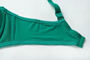 Green bra side wing detail close up, showing adjustable strap, soft fabric and lace trim.