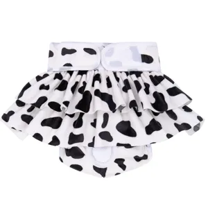 Close-up detail of black and white cow print pet dog sanitary skirt with ruffles and velcro.
