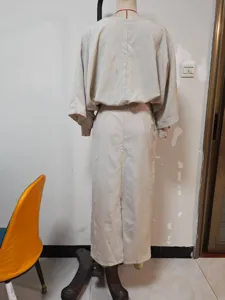 Detailed view of the beige linen batwing top and long skirt set, showing back design.