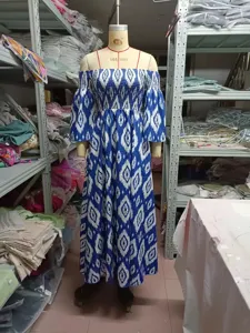 Vestido largo azul y blanco con hombros descubiertos, estampado geométrico y manga media.