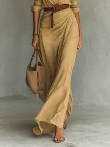 Detail view of a stylish khaki draped asymmetrical midi dress paired with a brown belt.